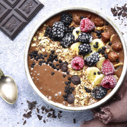 Chocolate banana smoothie bowl with frozen berries
